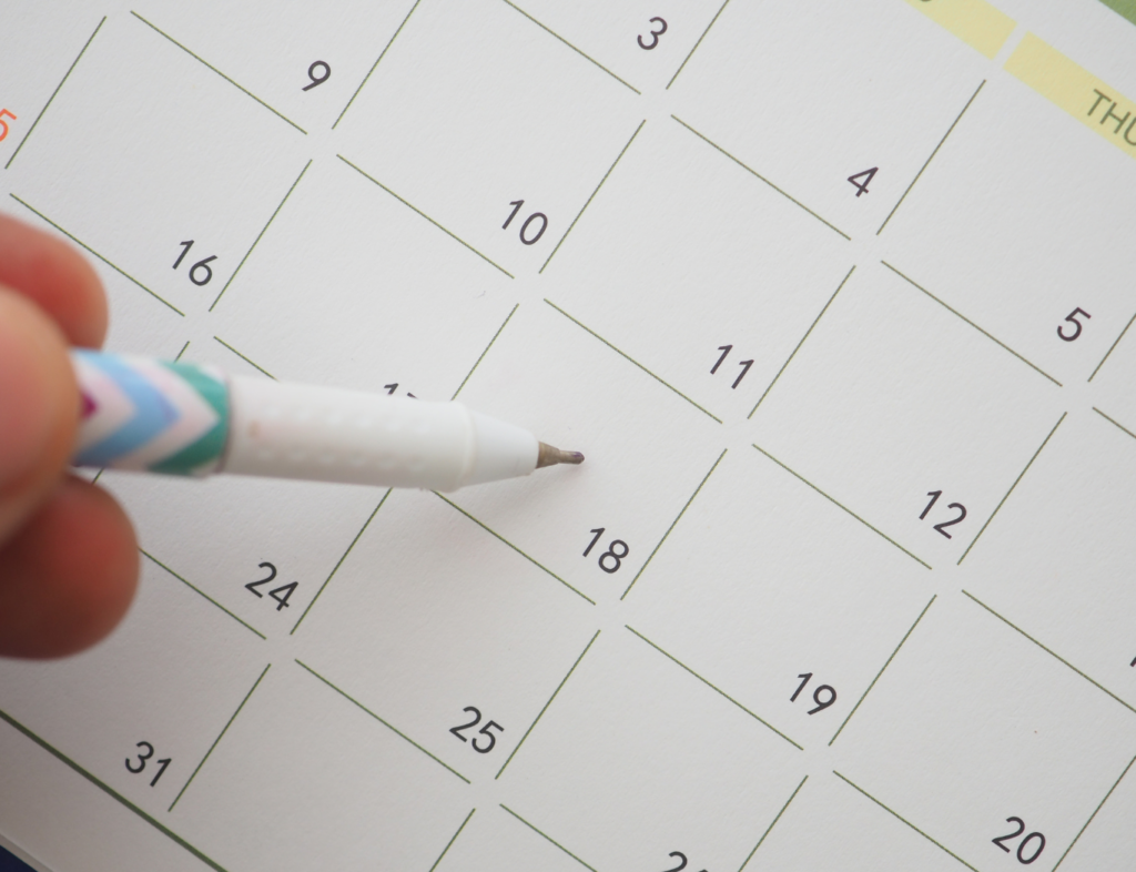 Hand marking date on calendar